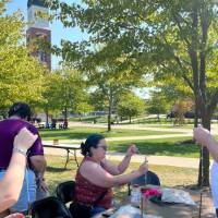 Students learning to use spindle whorls